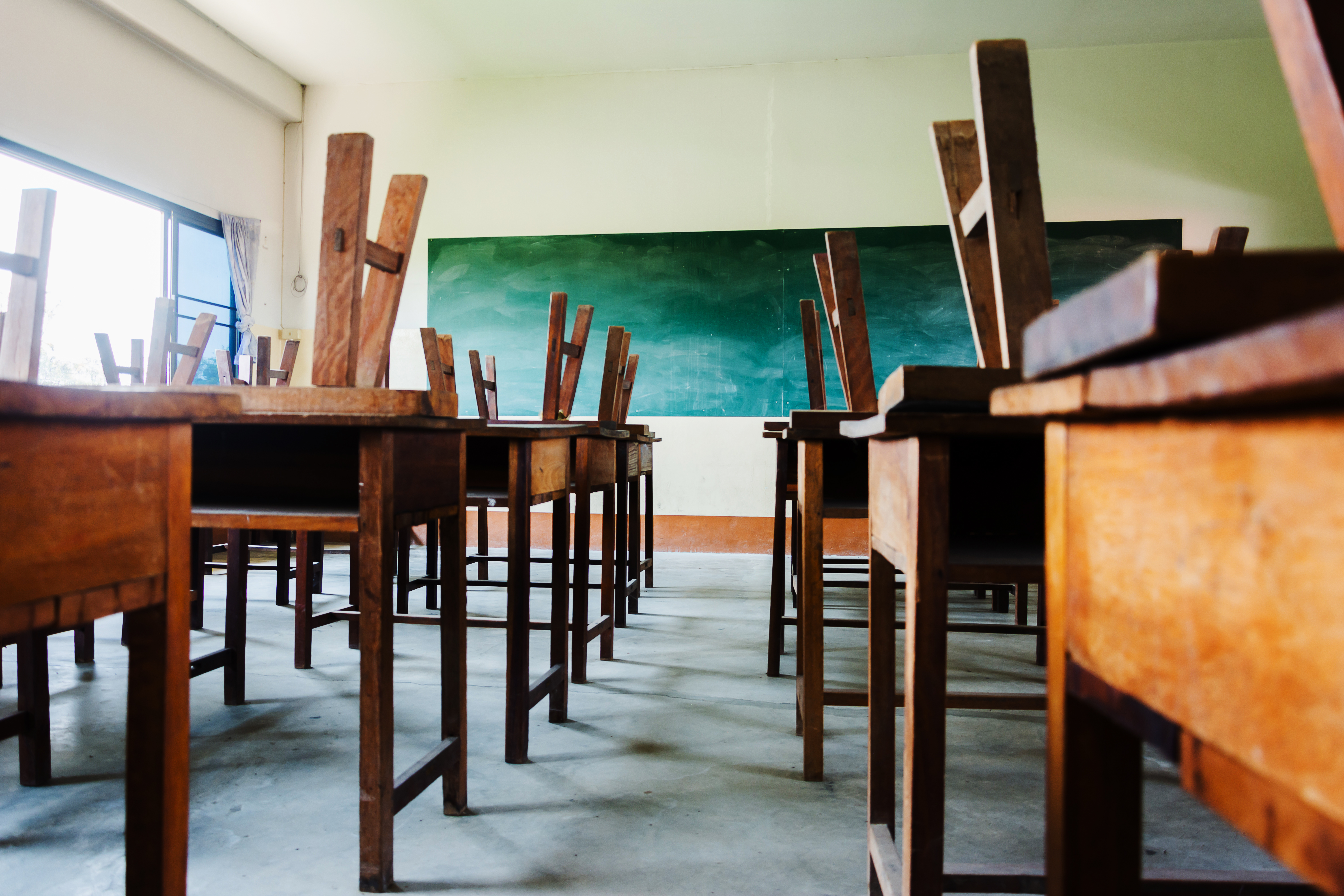 chair and table in class room with black board background, no student, school closed concept